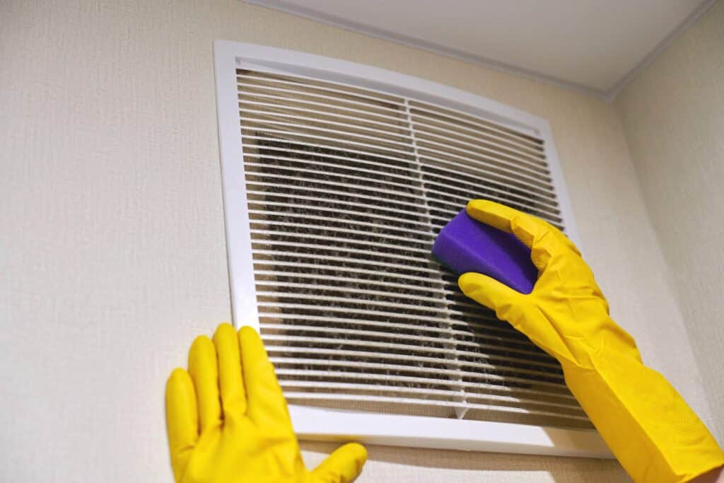 Recognizing and Improving Indoor Air Quality for a Healthier Home Hands in protective gloves clean air ventilation grill, HVAC