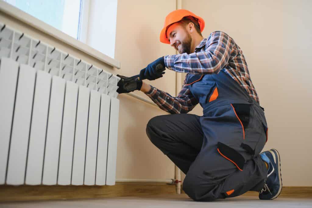 The Crucial Importance of Pre-Winter HVAC Servicing heating system installation and maintenance service. plumber installing radiator