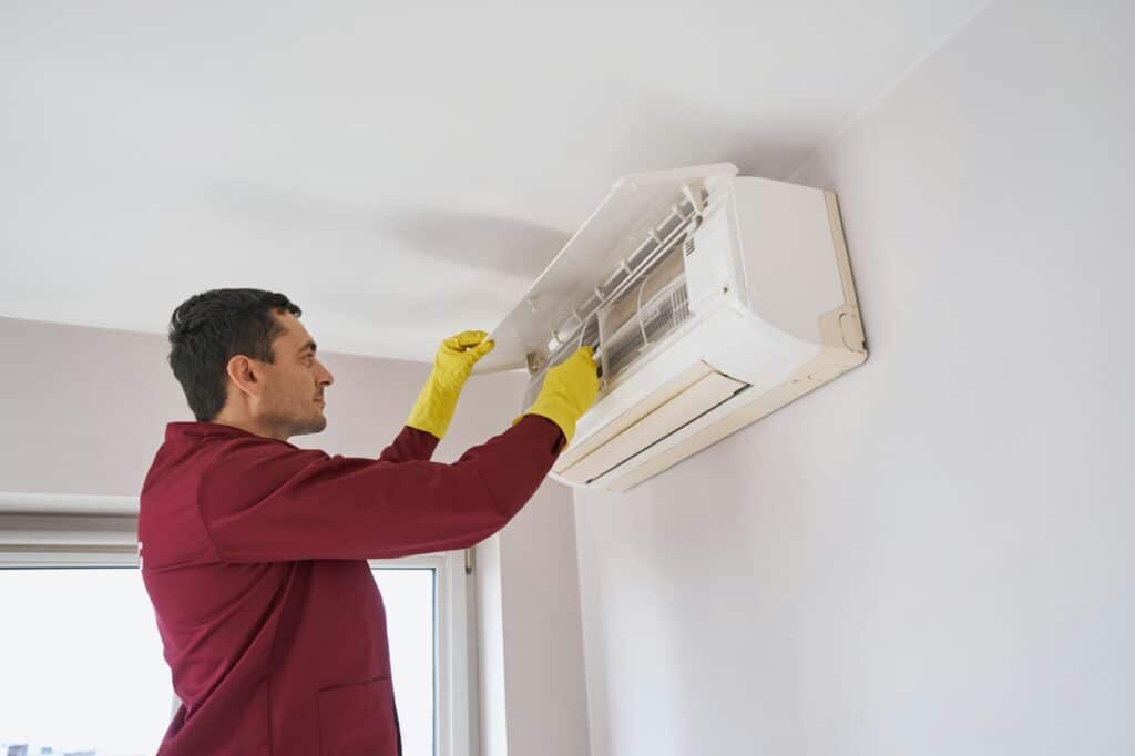 Concentrated cleaner in rubber gloves cleaning air-conditioning unit